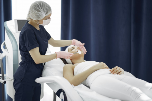 A woman getting a facial treatment from a skincare specialist