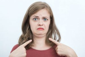 A woman pointing at her chin